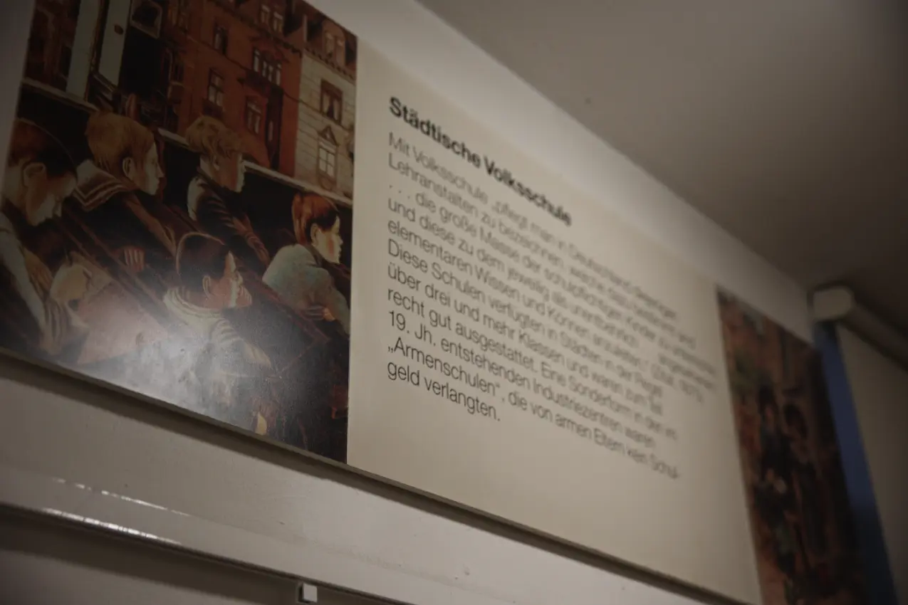 Informationstafel im Schulmuseum Ottweiler zum Thema „Städtische Volksschule“ mit historischer Abbildung und erklärendem Text.